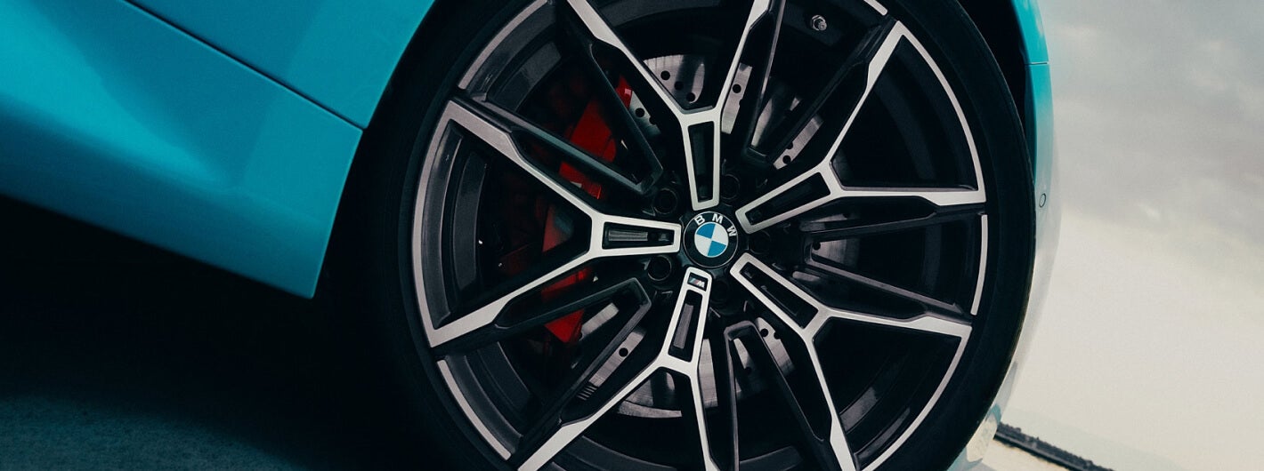 A low perspective close-up shot of a BMW wheel and wheelbase.