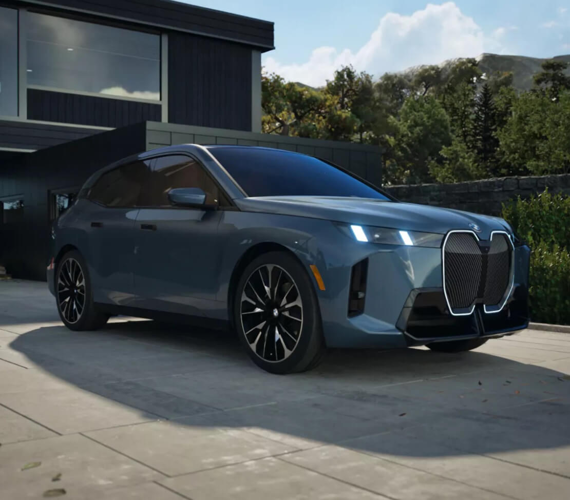 A blue BMW iX in a driveway
