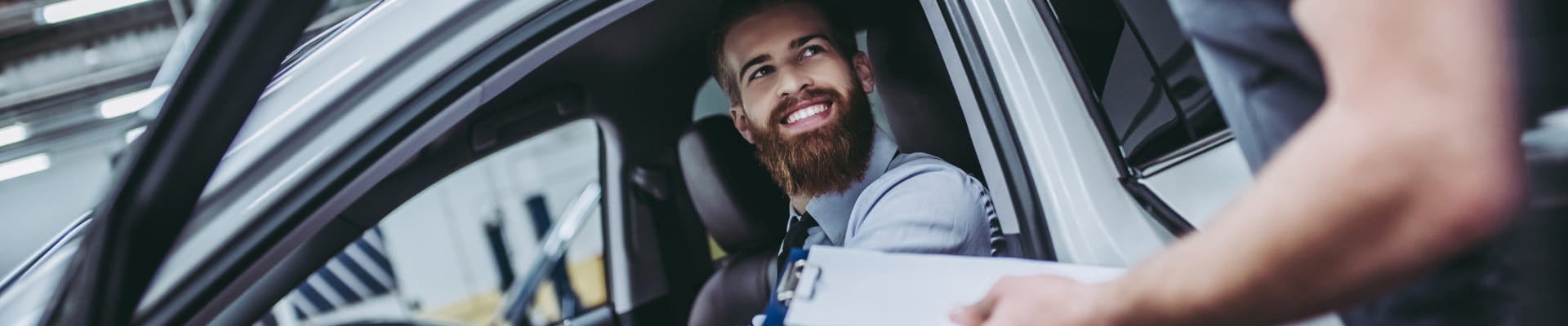 Customer speaking with a service advisor while seated inside a vehicle.